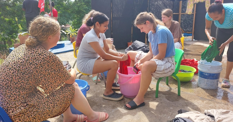 Kleren wassen met vrouwen uit de lokale gemeenschap.